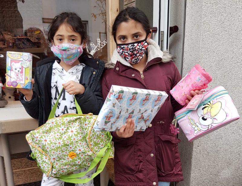 Zwei Kinder mit Geschenken in den Händen.